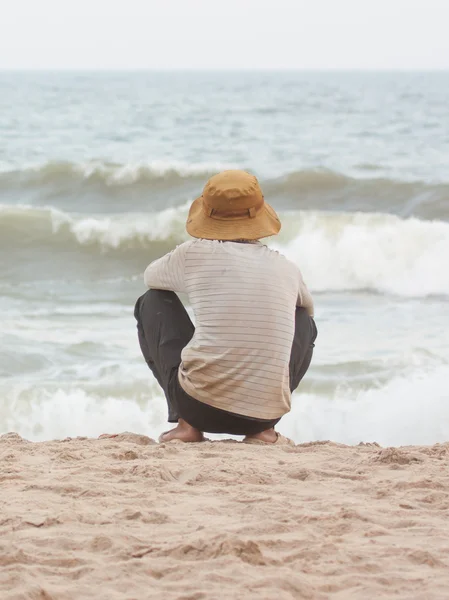 Uomo seduto sulla spiaggia a sud del mare cinese — Foto Stock