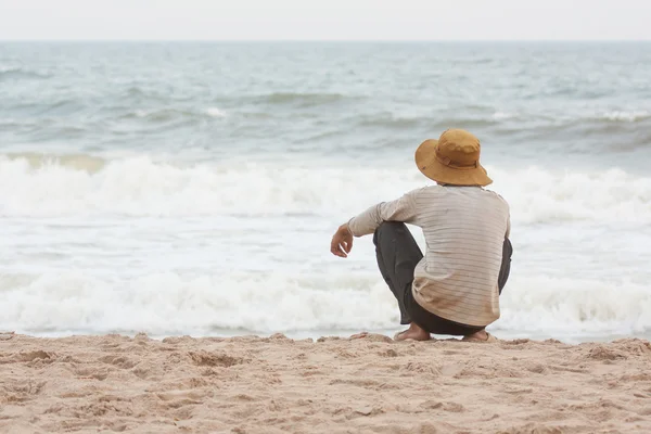 Uomo seduto sulla spiaggia a sud del mare cinese — Foto Stock