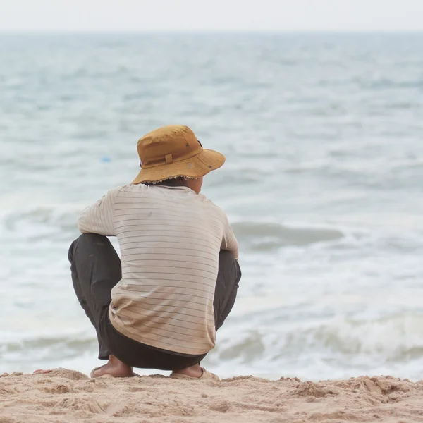 Uomo seduto sulla spiaggia a sud del mare cinese — Foto Stock