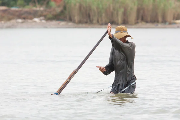 Vietnamský rybář hledá hady a náboje v — Stock fotografie