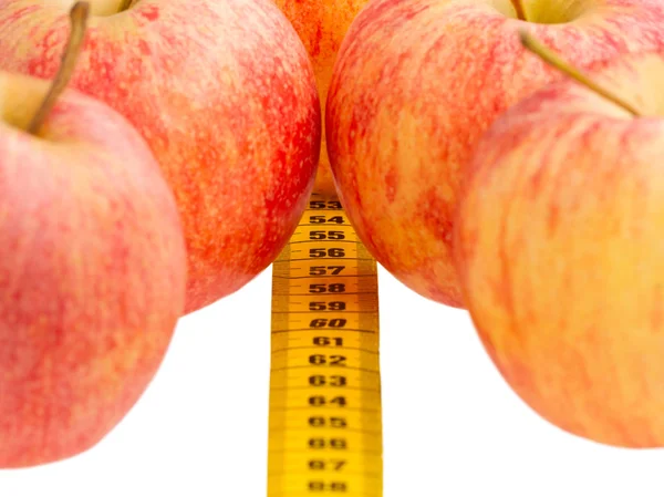 Röda äpplen med en gul måttband — Stockfoto
