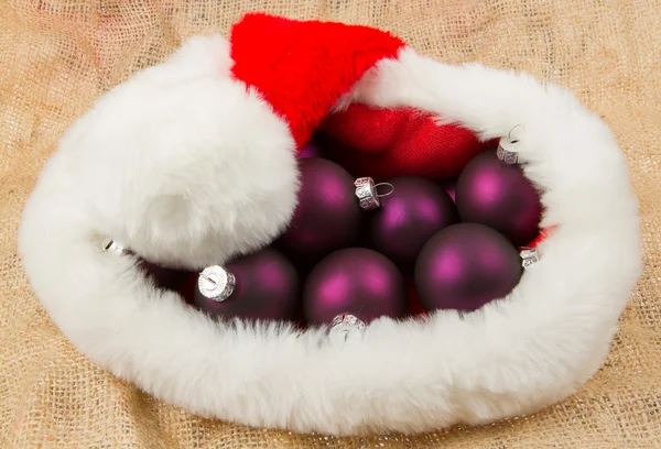 Santas hatt fylld med julgranskulor — Stockfoto