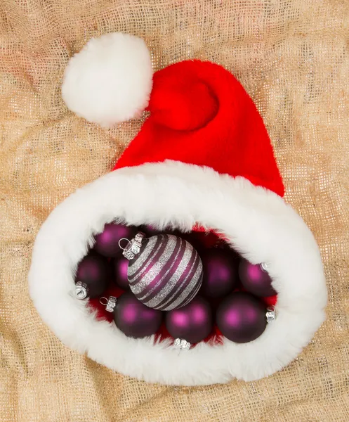 Santas hatt fylld med julgranskulor — Stockfoto