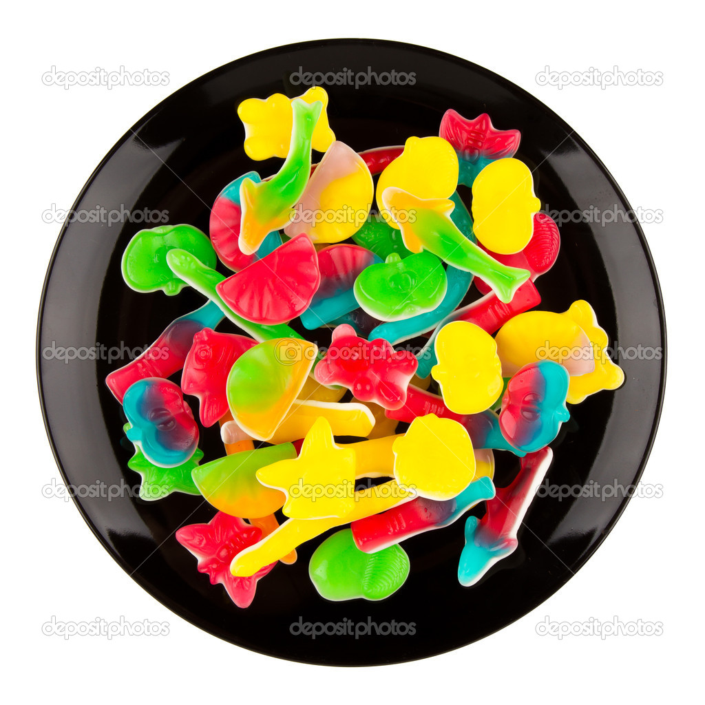 Colorful candies in many different shapes isolated on a black pl