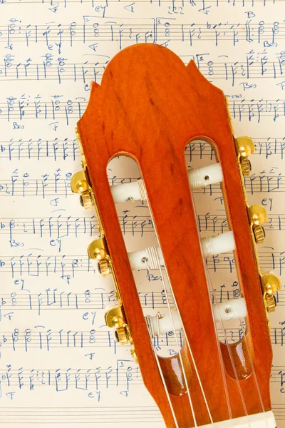 Old music sheet and a guitar — Stock Photo, Image