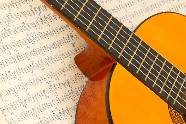 Old music sheet and a guitar — Stock Photo, Image