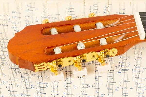 Old music sheet and a guitar — Stock Photo, Image