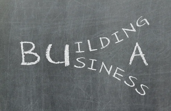 Building a business written on a chalkboard — Stock Photo, Image