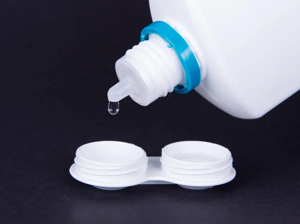 Lens casing and bottle of water isolated on black — Stock Photo, Image