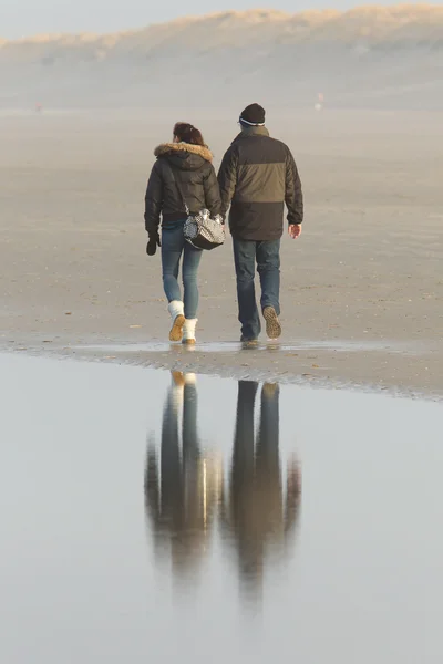 Casal andando em uma praia holandesa — Fotografia de Stock