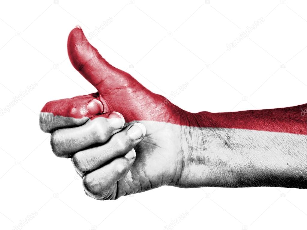 Old woman with arthritis giving the thumbs up sign, wrapped in f