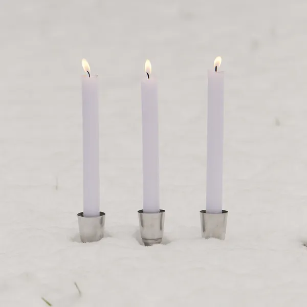 Tre brinnande ljus i snön — Stockfoto
