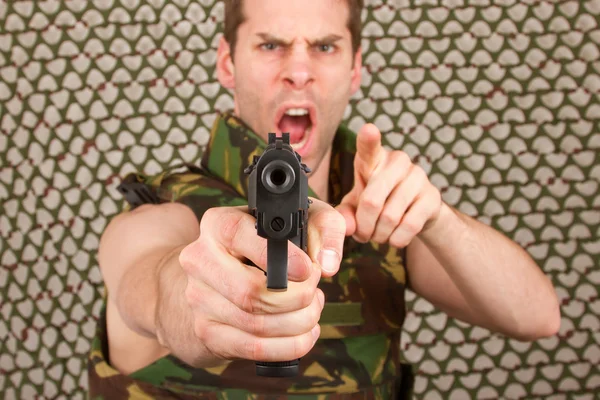 Soldaat in camouflage vest houdt een pistool — Stockfoto
