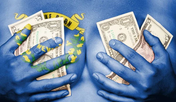 Dívka zpocený zahrnuty její prsa s penězi, vlajka nevada — Stock fotografie