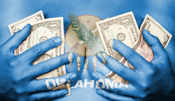 Sweaty girl covered her breast with money, flag of Oklahoma — Stock Photo, Image