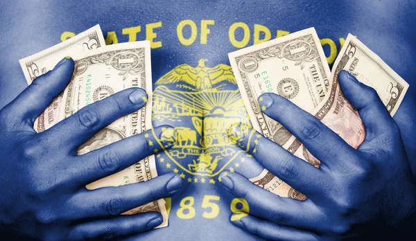 Sweaty girl covered her breast with money, flag of Oregon — Stock Photo, Image