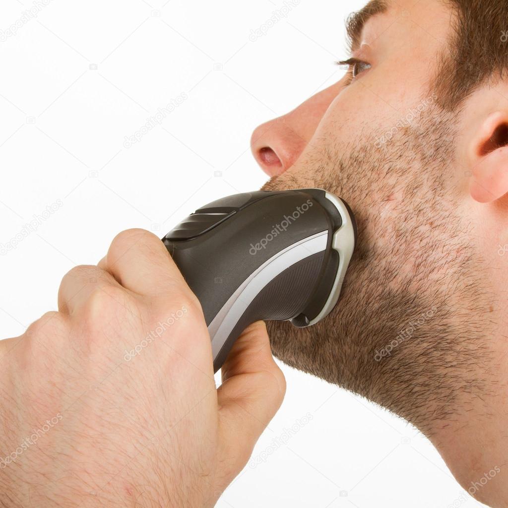 Young man shaving his beard off