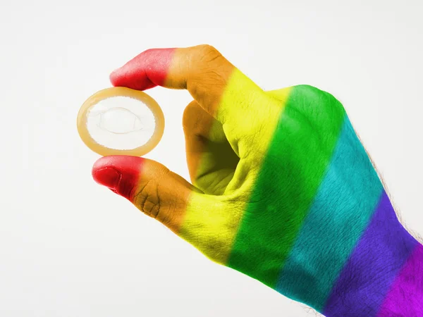 Männchen gibt ein Kondom, Muster der Regenbogenfahne — Stockfoto