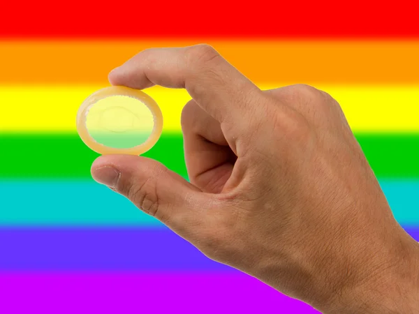 Αρσενικό, δίνοντας ένα προφυλακτικό, το ουράνιο τόξο σημαία μοτίβο — Φωτογραφία Αρχείου
