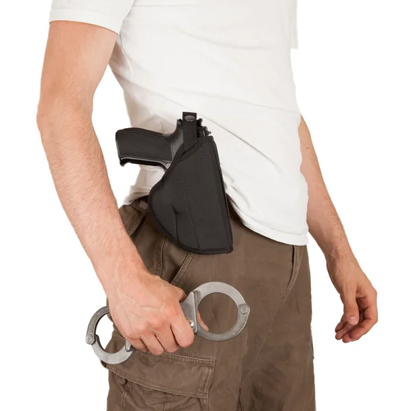 Close-up of a man with a gun and handcuffs — Stock Photo, Image