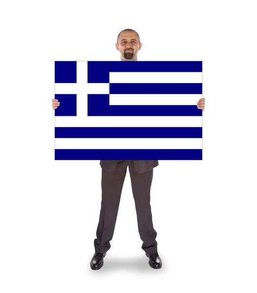 Smiling businessman holding a big card, flag of Greece — Stock Photo, Image