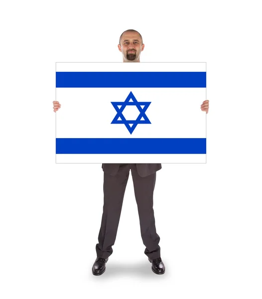 Empresário sorridente segurando um cartão grande, bandeira de Israel — Fotografia de Stock