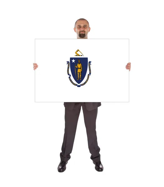 Empresário sorridente segurando um cartão grande, bandeira de Massachusetts — Fotografia de Stock
