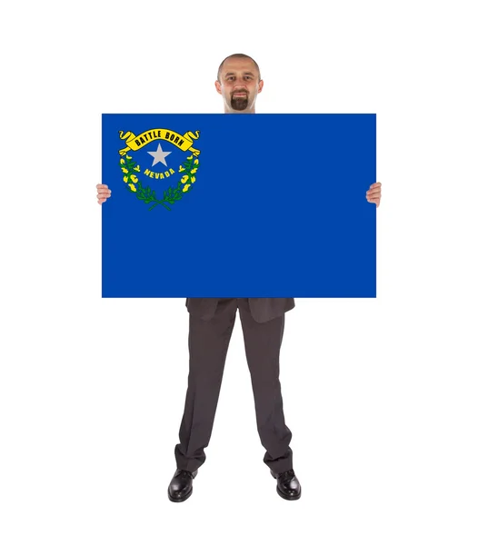Büyük bir kart, nevada bayrağı tutarak gülümseyen iş adamı — Stok fotoğraf
