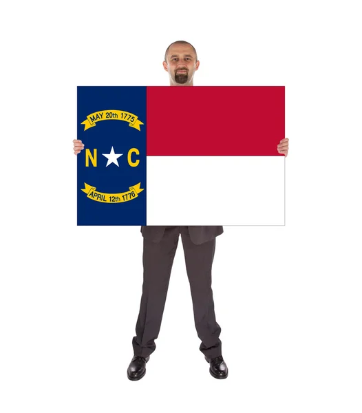 Smiling businessman holding a big card, flag of North Carolina — Stock Photo, Image