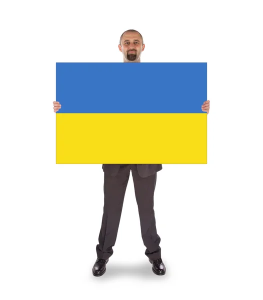 Büyük bir kart, Ukrayna bayrağı tutarak gülümseyen iş adamı — Stok fotoğraf