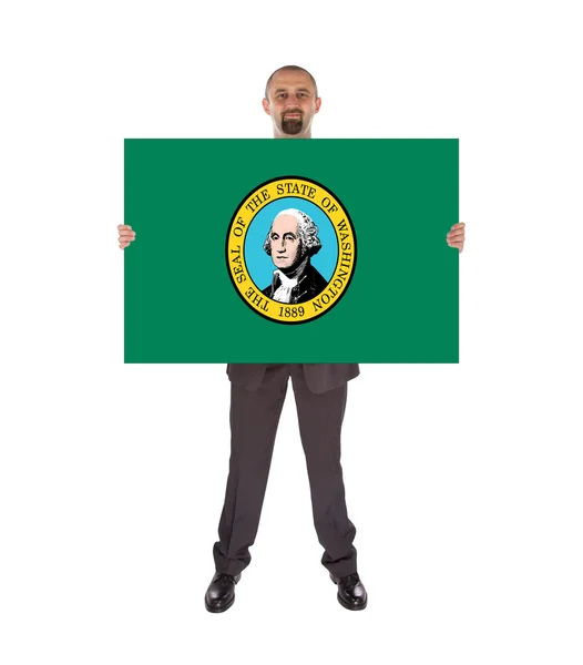 Un hombre de negocios sonriente sosteniendo una gran tarjeta, bandera de Washington — Foto de Stock
