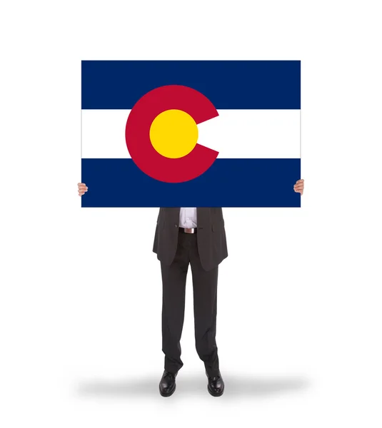 Smiling businessman holding a big card, flag of Colorado — Stock Photo, Image