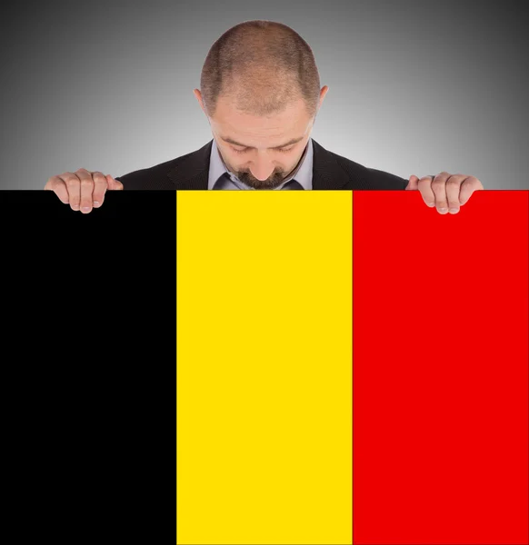 Pebisnis tersenyum memegang kartu besar, bendera Belgia — Stok Foto