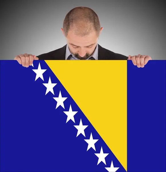 Lächelnder Geschäftsmann mit großer Karte, Flagge von Bosnien und Herzegowina — Stockfoto