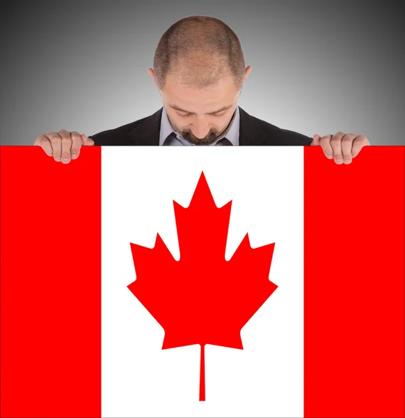 Uomo d'affari sorridente in possesso di una grande carta, bandiera del Canada — Foto Stock