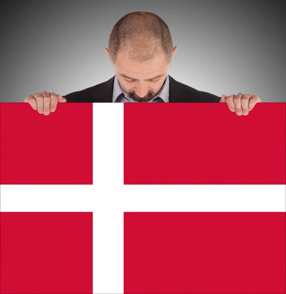 Smiling businessman holding a big card, flag of Denmark — Stock Photo, Image