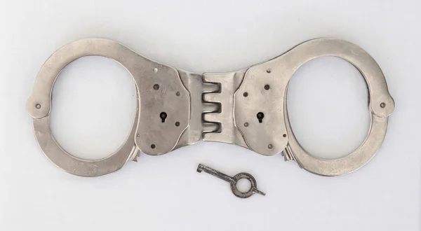 Старые наручники и ключ — стоковое фото