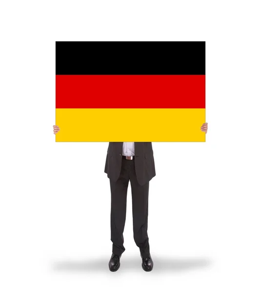 ドイツの旗の大きなカードを保持しているビジネスマンの笑みを浮かべてください。 — ストック写真