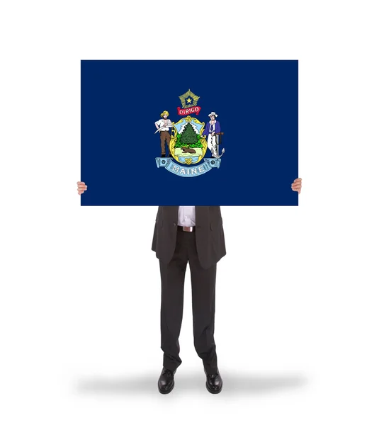 Un hombre de negocios sonriente sosteniendo una tarjeta grande, bandera de Maine —  Fotos de Stock
