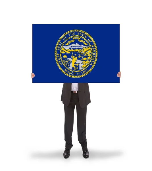 Büyük bir kart, nebraska bayrağı tutarak gülümseyen iş adamı — Stok fotoğraf