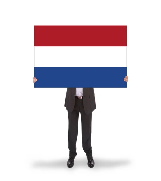 Smiling businessman holding a big card, flag of the Netherlands — Stock Photo, Image