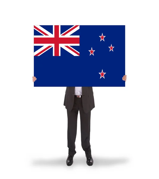 Smiling businessman holding a big card, flag of New Zealand — Stock Photo, Image