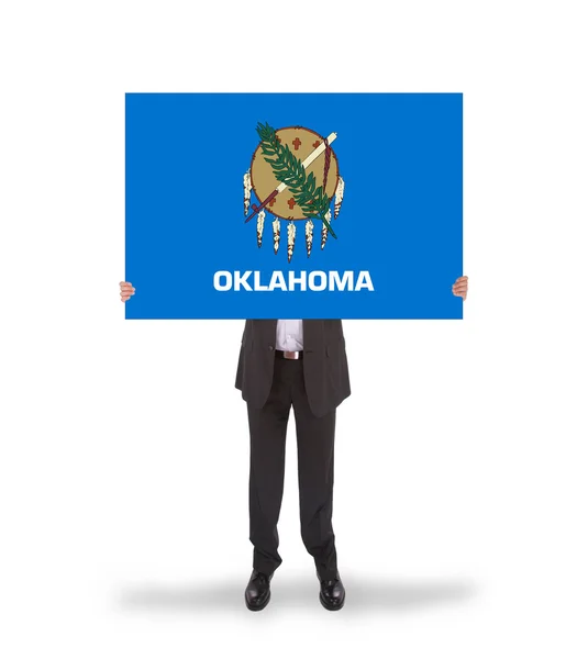 Smiling businessman holding a big card, flag of Oklahoma — Stock Photo, Image