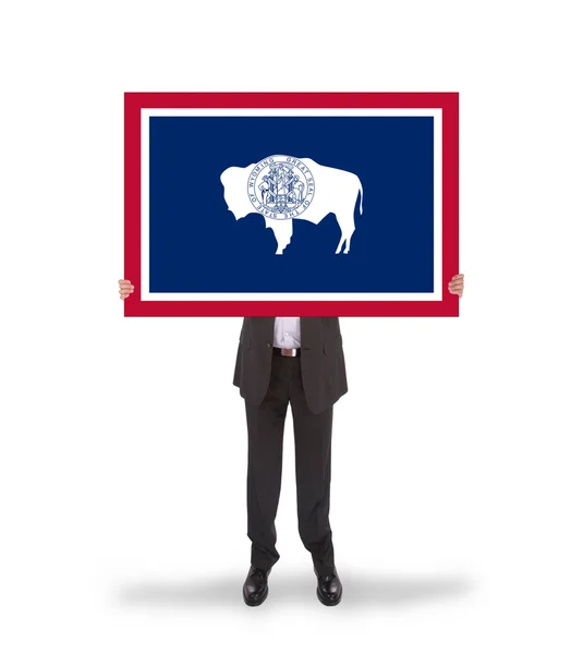 Smiling businessman holding a big card, flag of Wyoming — Stock Photo, Image