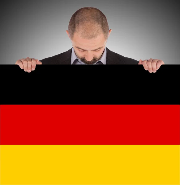 Smiling businessman holding a big card, flag of Germany — Stock Photo, Image