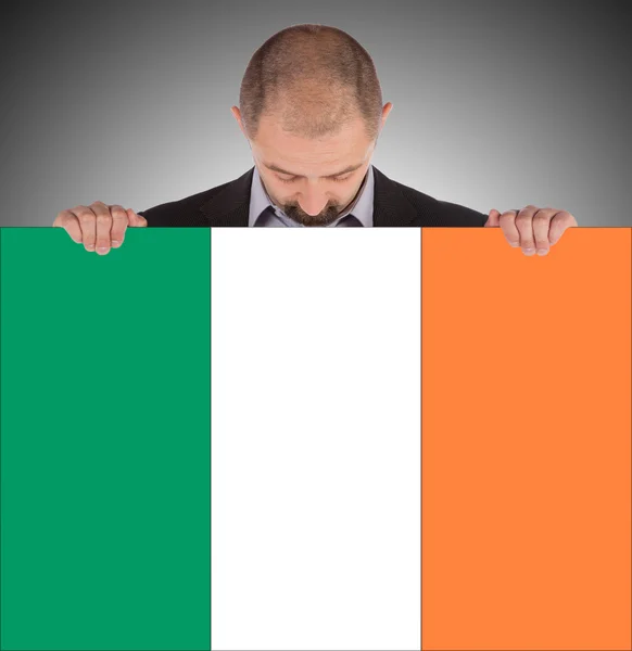 Homme d'affaires souriant tenant une grande carte, drapeau de l'Irlande — Photo