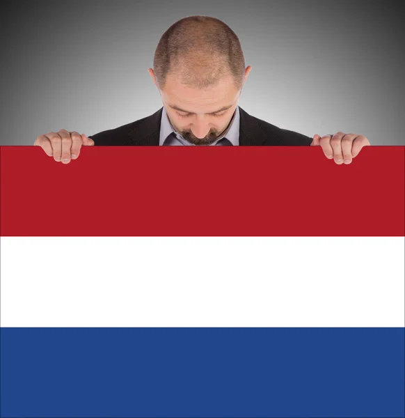 Lachende zakenman met een grote kaart, vlag van Nederland — Stockfoto