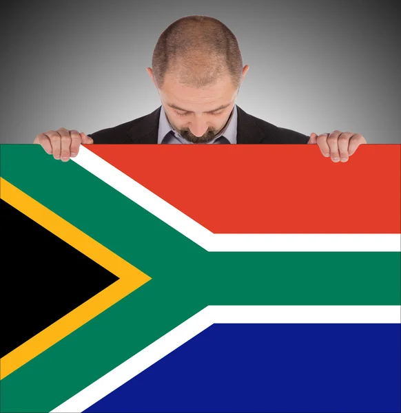 Smiling businessman holding a big card, flag of South Africa — Stock Photo, Image