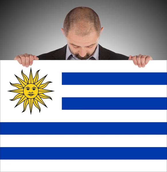Lachende zakenman met een grote kaart, vlag van uruguay — Stockfoto