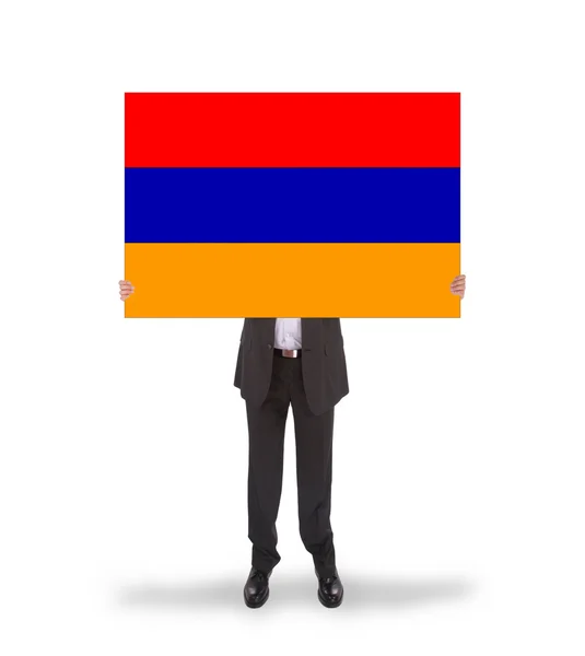 Empresario sosteniendo una tarjeta grande, bandera de Armenia — Foto de Stock